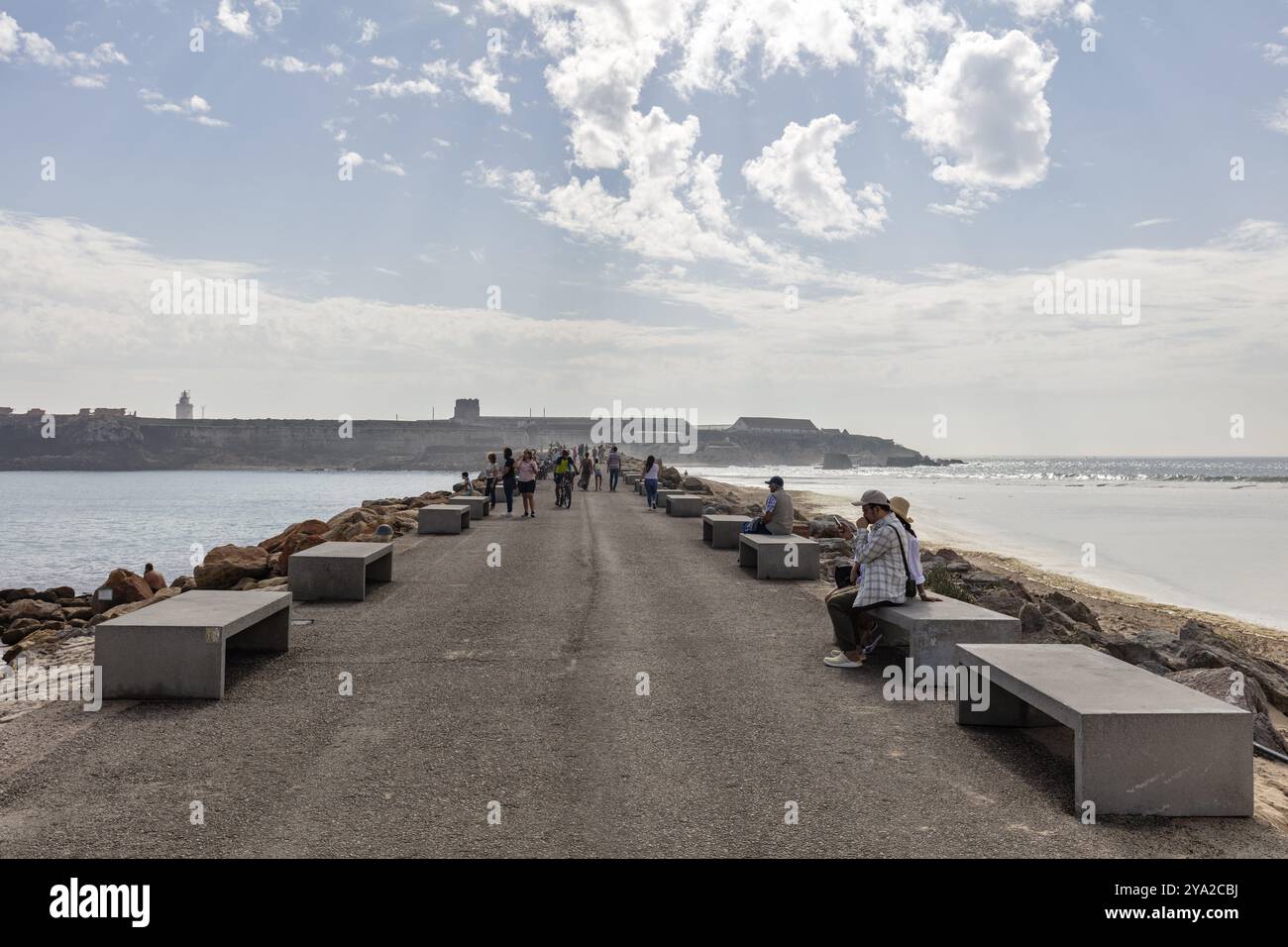 Passeggiata con panchine e gente che gode della vista sul mare, Tarifa Foto Stock