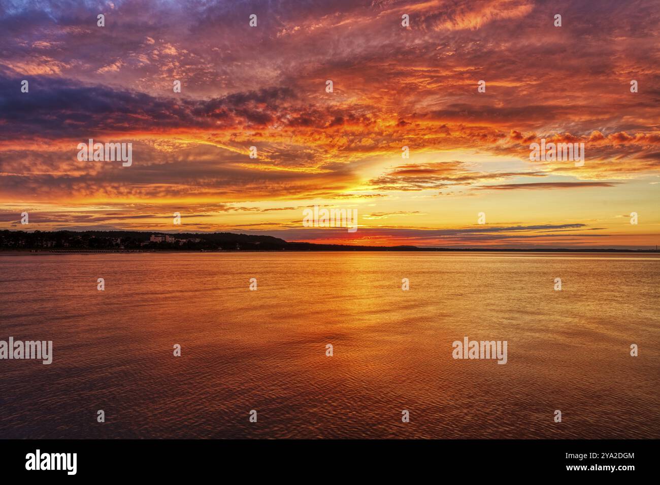 Tramonto rosso-arancio luminoso sul mare calmo, Ruegen Foto Stock