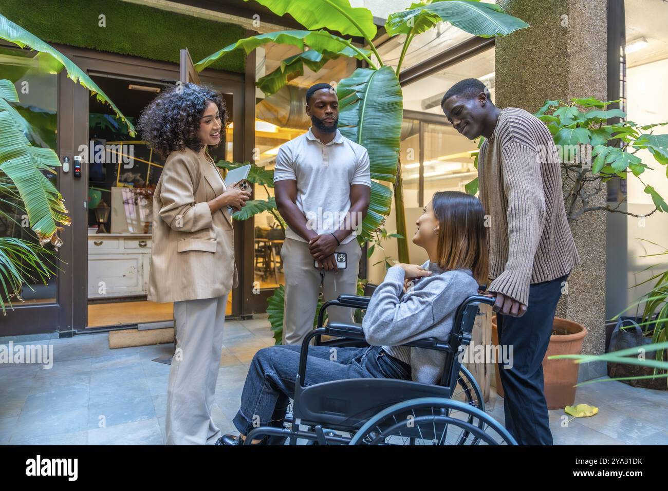 Donna disabile che porta con colleghi multietnici e diversi colleghi fuori dal moderno ufficio di coworking Foto Stock