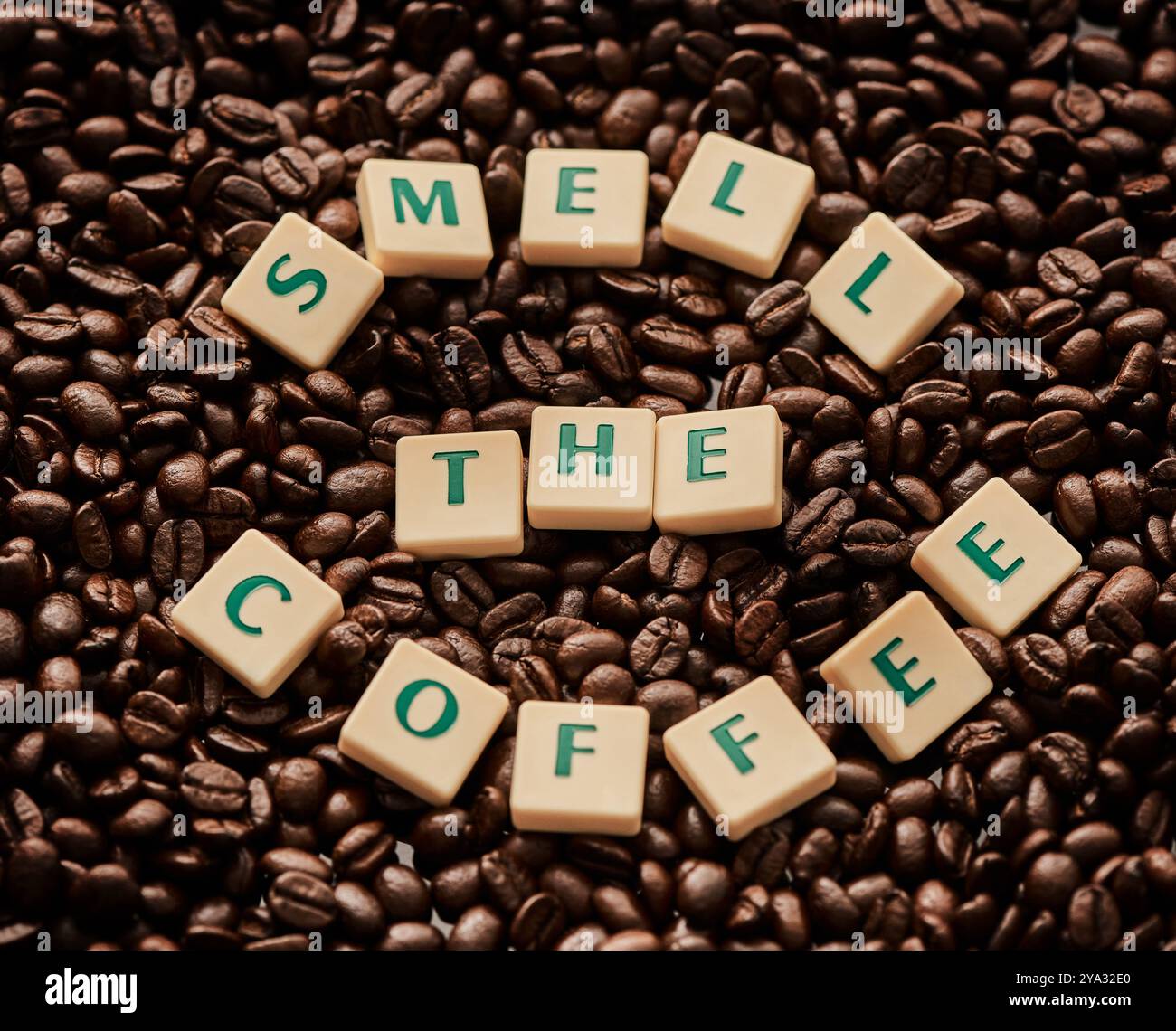 Chicchi, blocchi e lettere con caffè, biologico e amore per la produzione, la tostatura e l'industria naturale della caffeina. Piastrelle, consistenza e ortografia per l'espresso Foto Stock