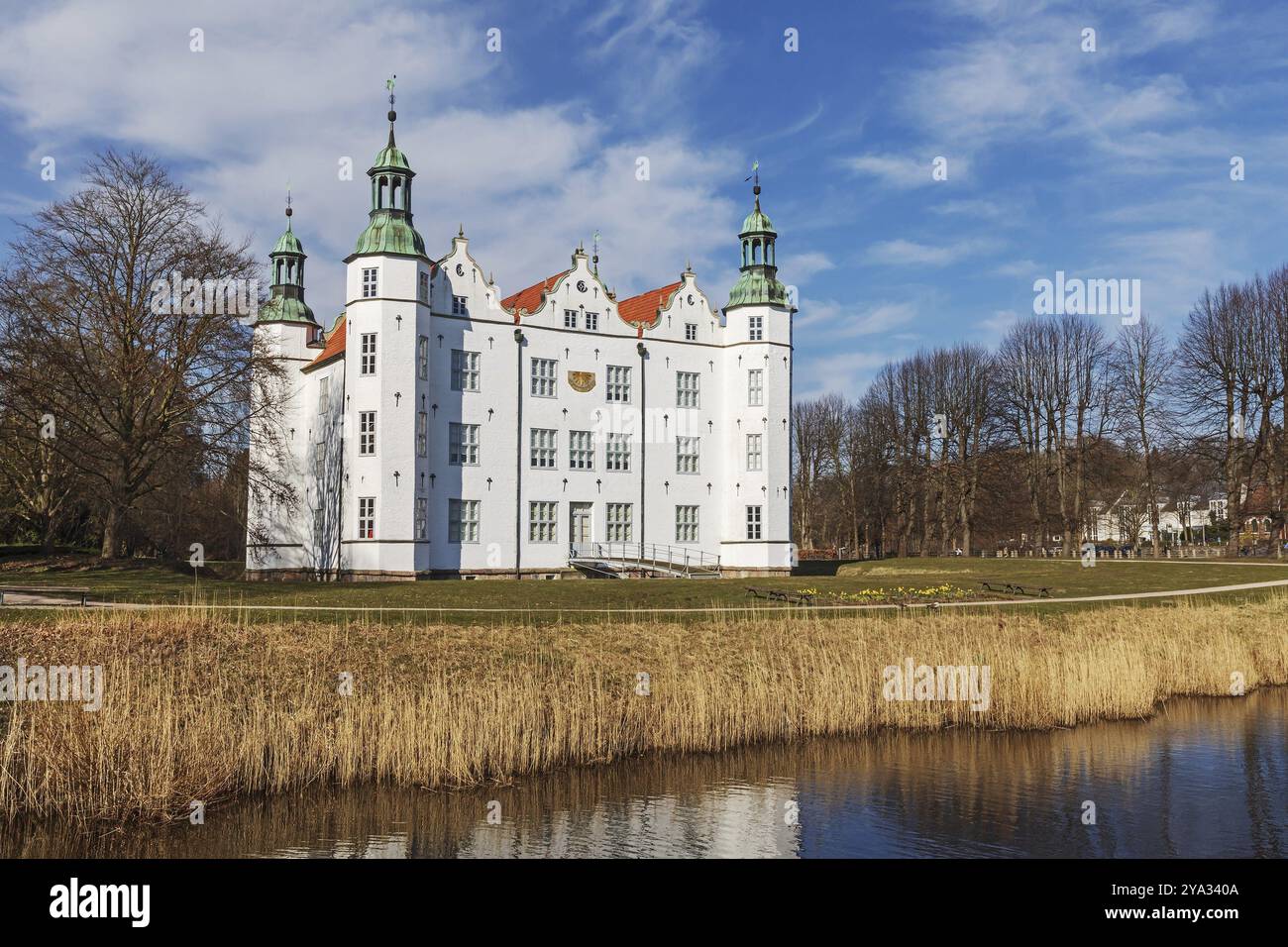 Schloss Ahrensburg, ex Herrenhaus (Mansion) all'inizio della primavera nello Schleswig-Holstein, Germania, con riflessioni nel fossato, in Europa Foto Stock