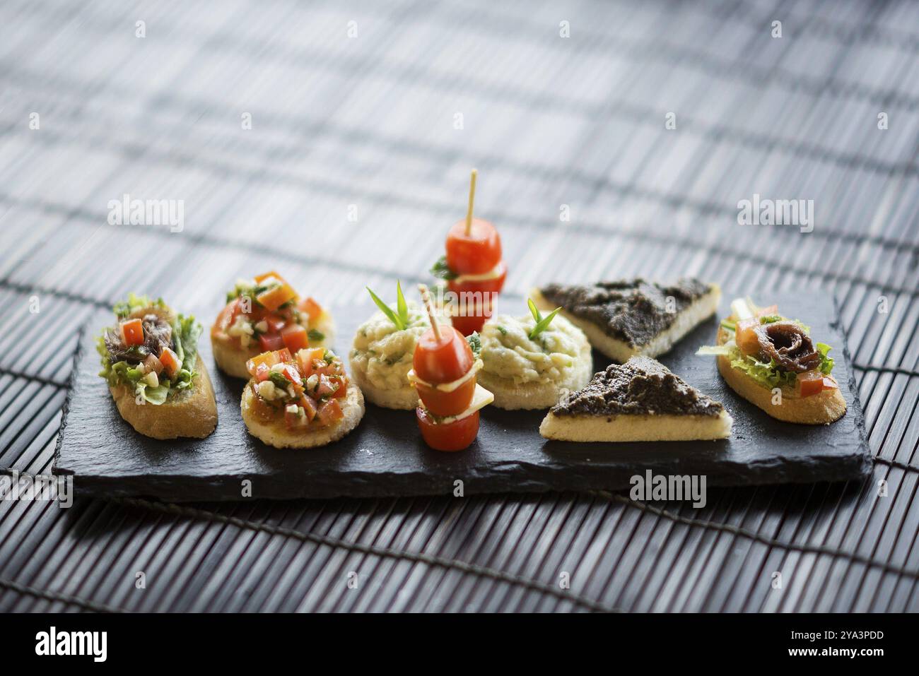 Piatto misto di tapas fusion internazionali con tapenade, acciughe, patè di pesce e insalata Foto Stock