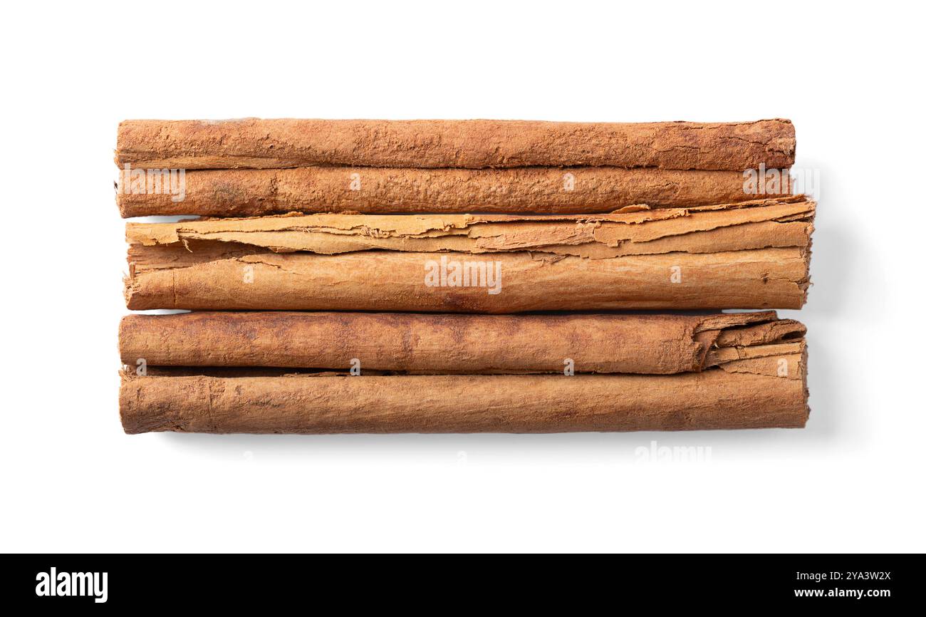 Bastoncini di cannella Ceylon, dall'alto. Tre strisce di corteccia secca del vero albero di cannella, Cinnamomum verum, disposte parallelamente l'una all'altra. Foto Stock