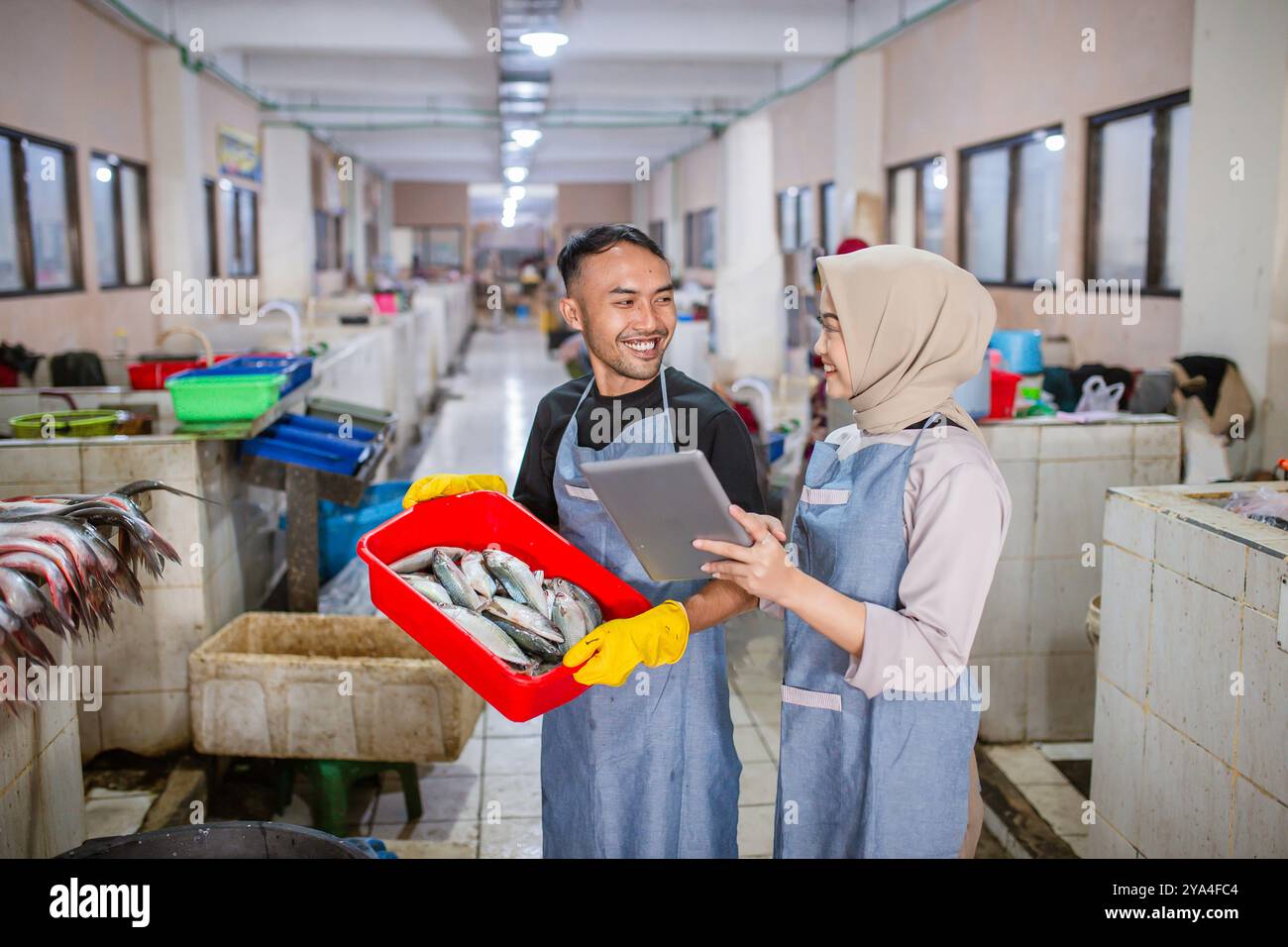 Interazione con il mercato del pesce: I venditori discutono del pescato fresco nella struttura moderna Foto Stock
