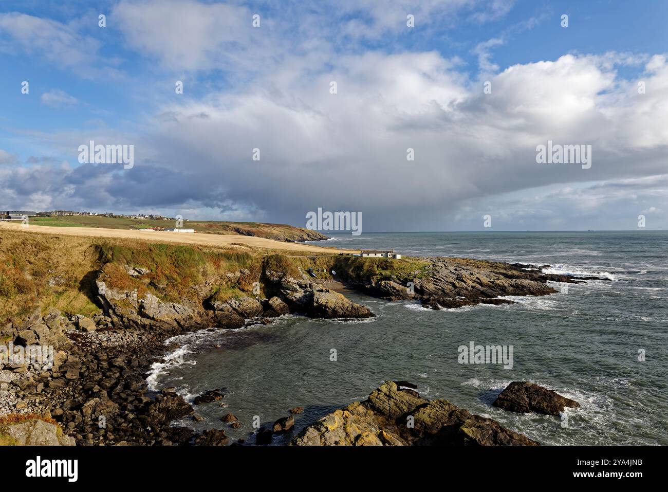 Una vista della Baia di Portlethen vicino a Stonehaven che guarda a nord con la Old Salmon Fishing Station sul promontorio con il piccolo porto sottostante. Foto Stock