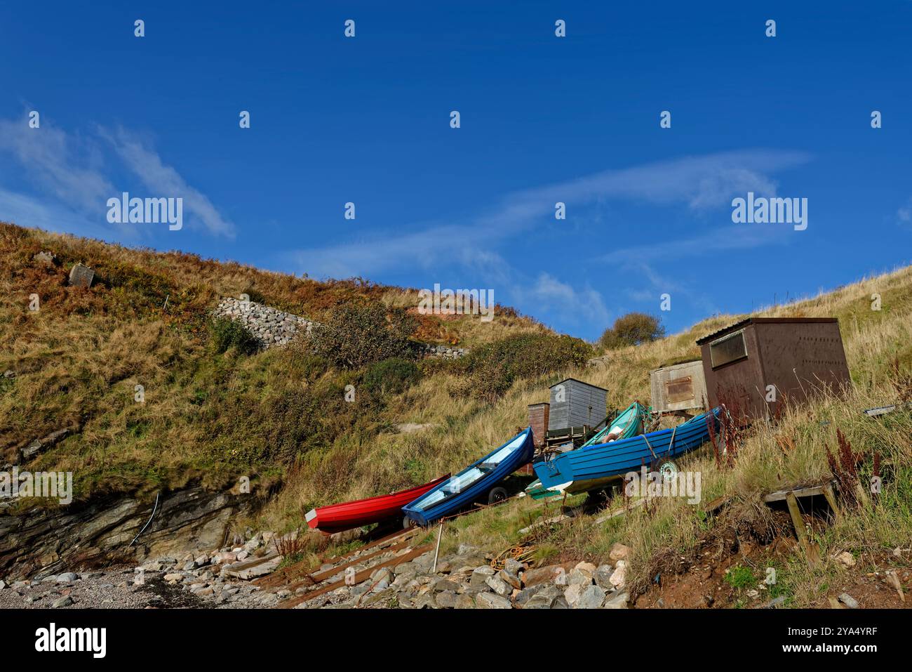 Il piccolo porto riparato a Old Portlethen sulla costa dell'Aberdeenshire, con piccole barche da pesca si arenavano nella zona erbosa. Foto Stock