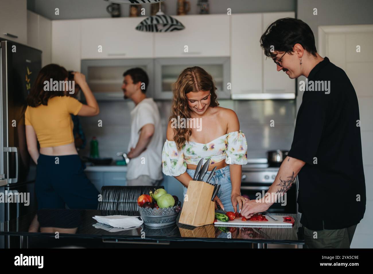 Amici che si godono una sessione di cucina informale in cucina Foto Stock