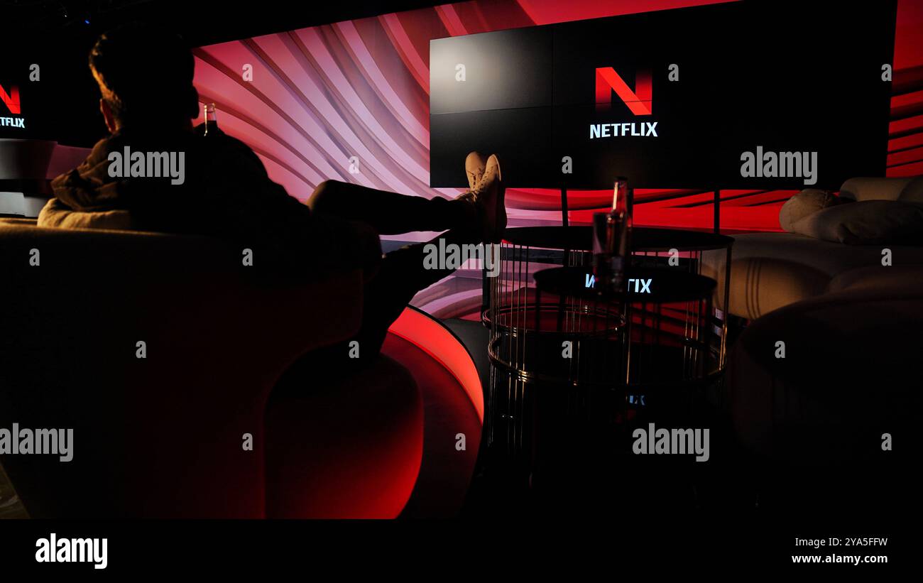 A un uomo piace guardare netflix su un enorme schermo tv Foto Stock