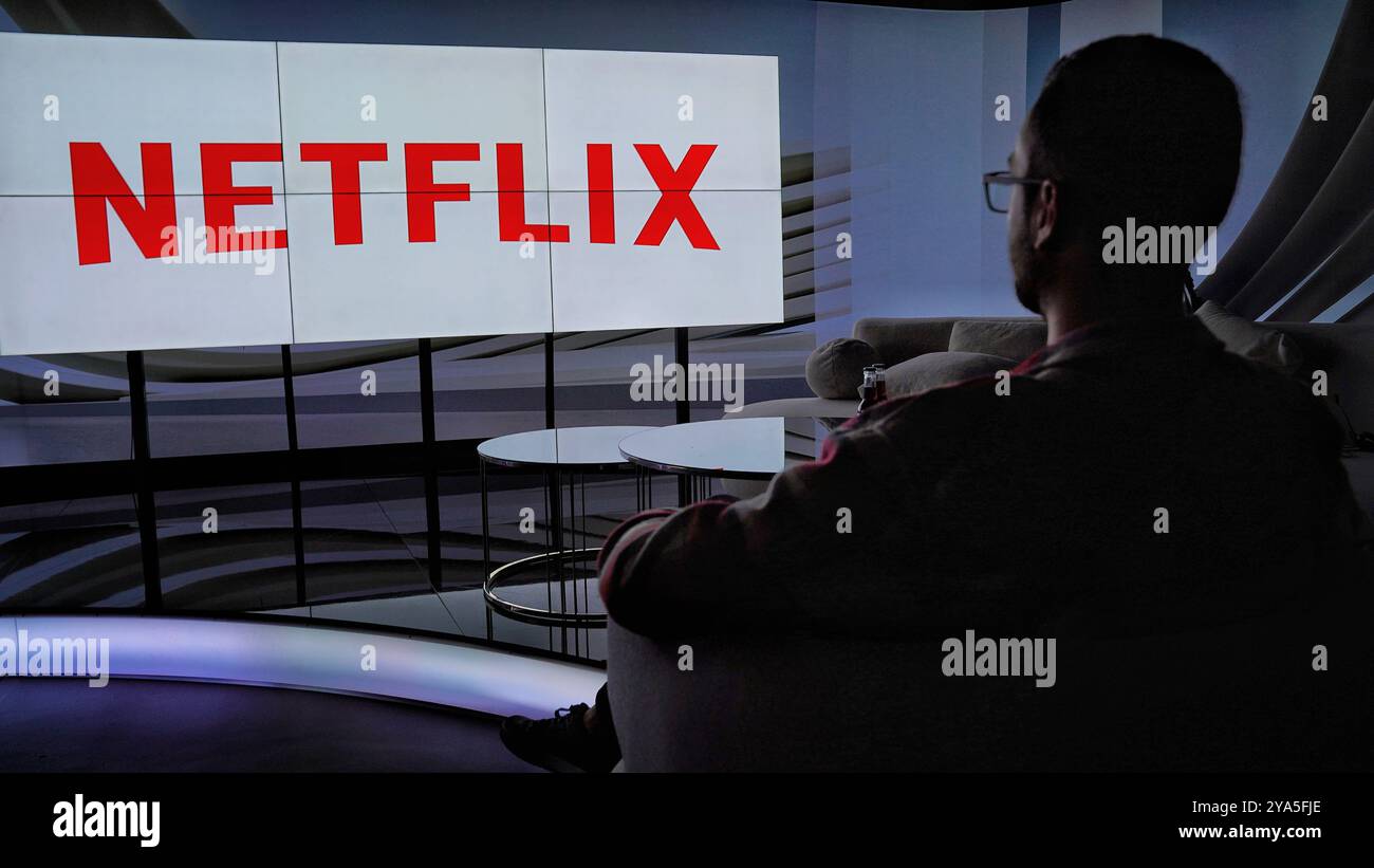 A un uomo piace guardare netflix su un enorme schermo tv Foto Stock