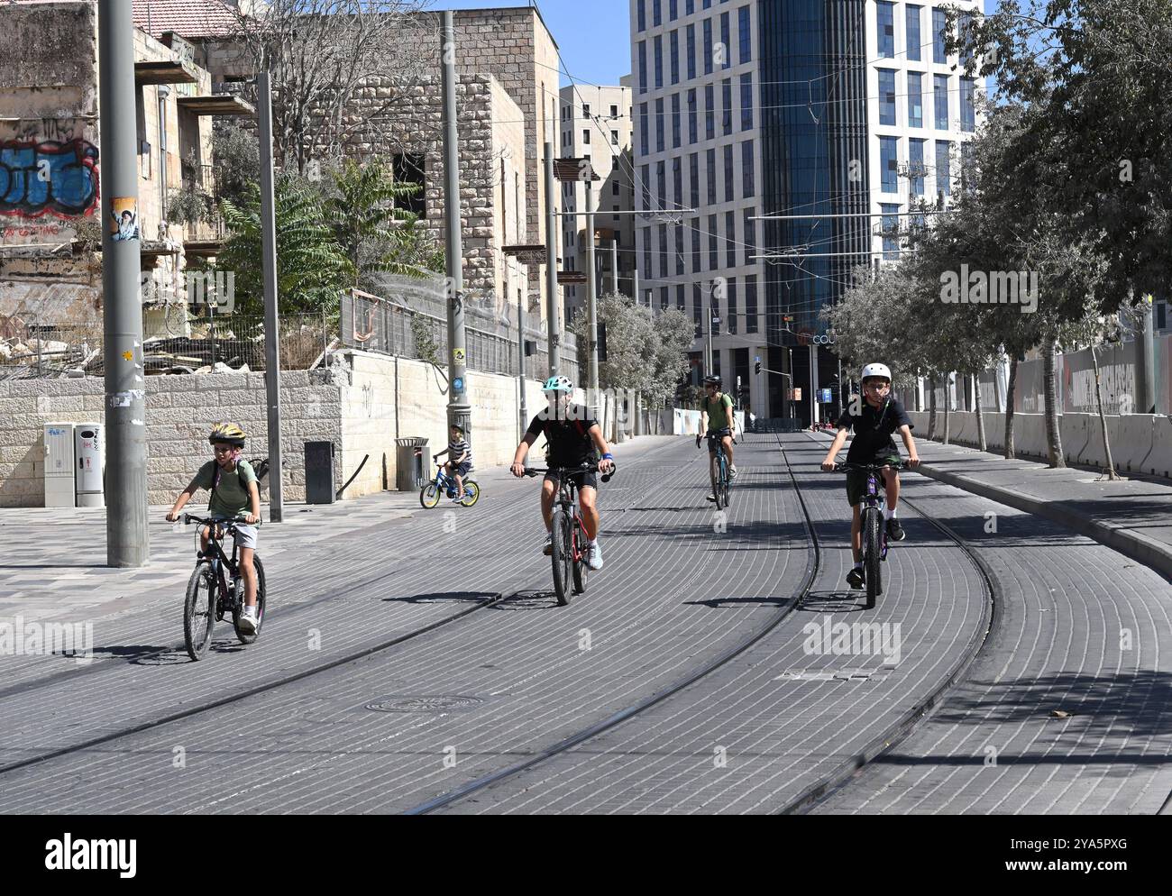 Gerusalemme, Israele. 12 ottobre 2024. Gli israeliani viaggiano in bicicletta sui binari della ferrovia leggera di Gerusalemme a Yom Kippur, il giorno dell'Espiazione, il giorno più sacro dell'anno ebraico sabato 12 ottobre 2024. Le strade e i sistemi ferroviari israeliani si fermano per 25 anni durante il digiuno e le preghiere dello Yom Kippur. Foto di Debbie Hill/ credito: UPI/Alamy Live News Foto Stock