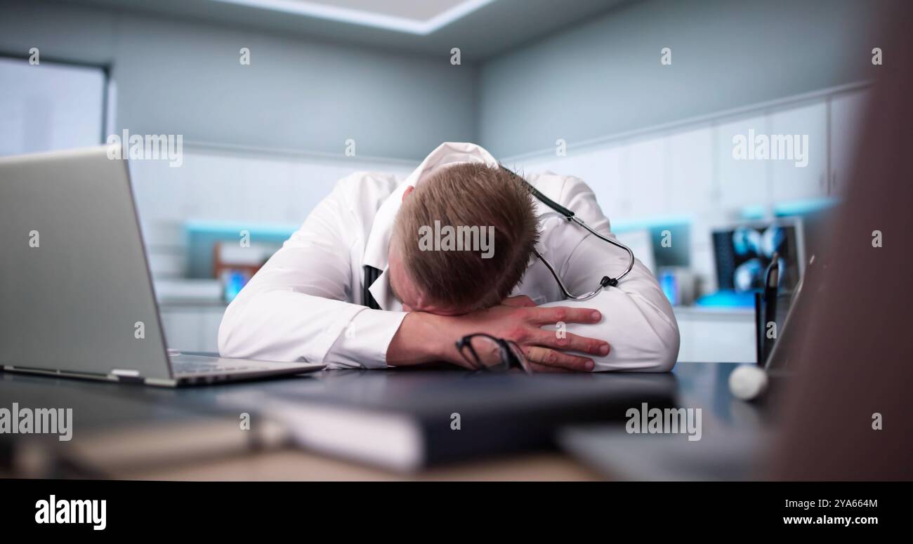 Annoiato medico medico uomo che dorme. Dipendente stanco e riposante Foto Stock