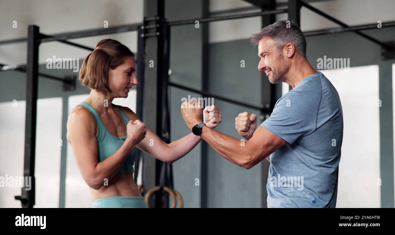 Coppia forte in palestra che mostra Biceps. Amicizia e divertimento. Motivazione per il fitness Foto Stock