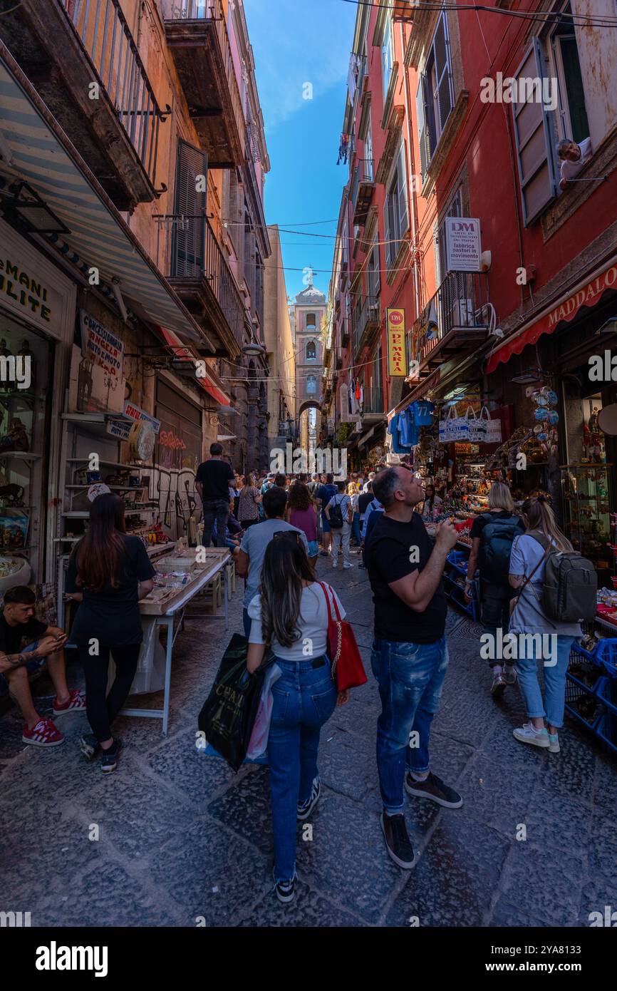 Napoli, Italia - 23 maggio 2024: Gruppo turistico che cammina lungo una pittoresca via di Napoli. Foto Stock