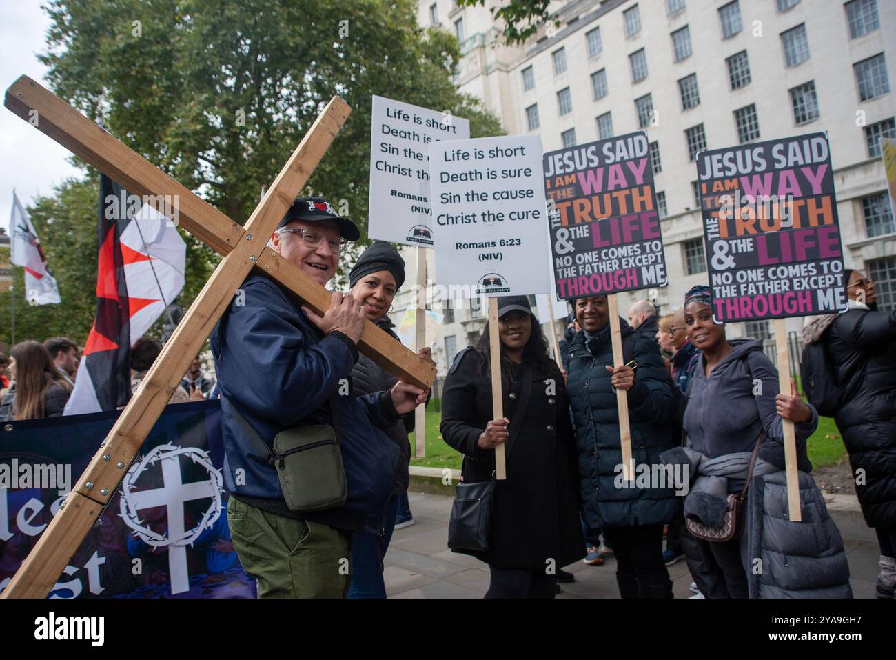 Londra, Regno Unito. 12 ottobre 2024. I cristiani posano per una foto con una croce e cartelli prima della marcia. Centinaia di cristiani marciarono attraverso il centro di Londra nell'evento chiamato "marcia per Gesù". Si tratta di una processione di lodi per le strade della città e che celebra la Signoria di Gesù Cristo. Credito: SOPA Images Limited/Alamy Live News Foto Stock