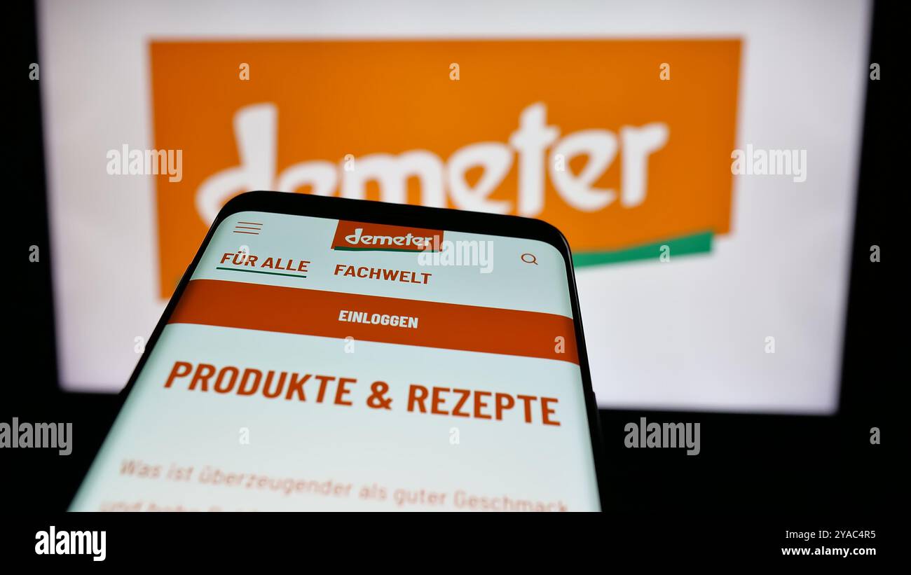 Telefono cellulare con sito web dell'organizzazione alimentare biologica tedesca Demeter sullo schermo davanti al logo. Mettere a fuoco in alto a sinistra sul display del telefono. Foto Stock