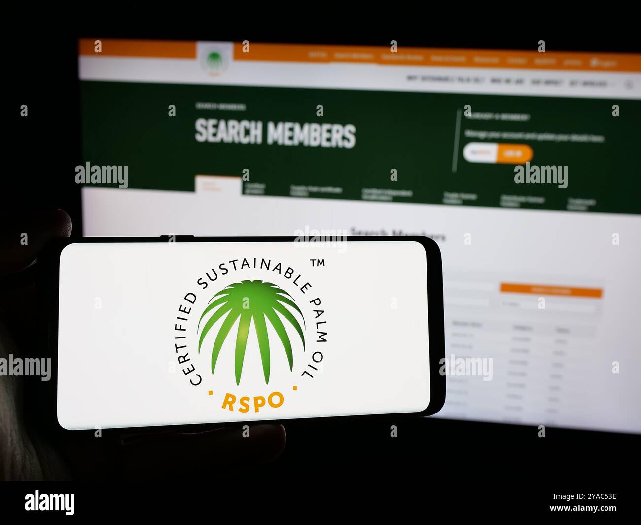 Persona che possiede uno smartphone con il logo Roundtable on Sustainable Palm Oil (RSPO) sullo schermo di fronte al sito Web. Mettere a fuoco il display del telefono. Foto Stock