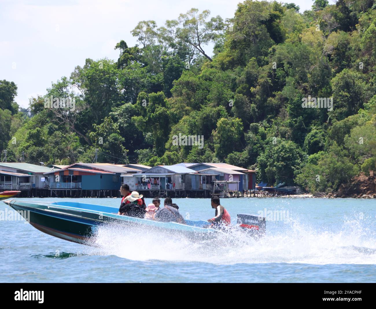 Un gruppo di persone sta navigando su un fiume. La barca è blu e bianca e si sta muovendo rapidamente. La gente indossa giubbotti di salvataggio e sembra essere Foto Stock