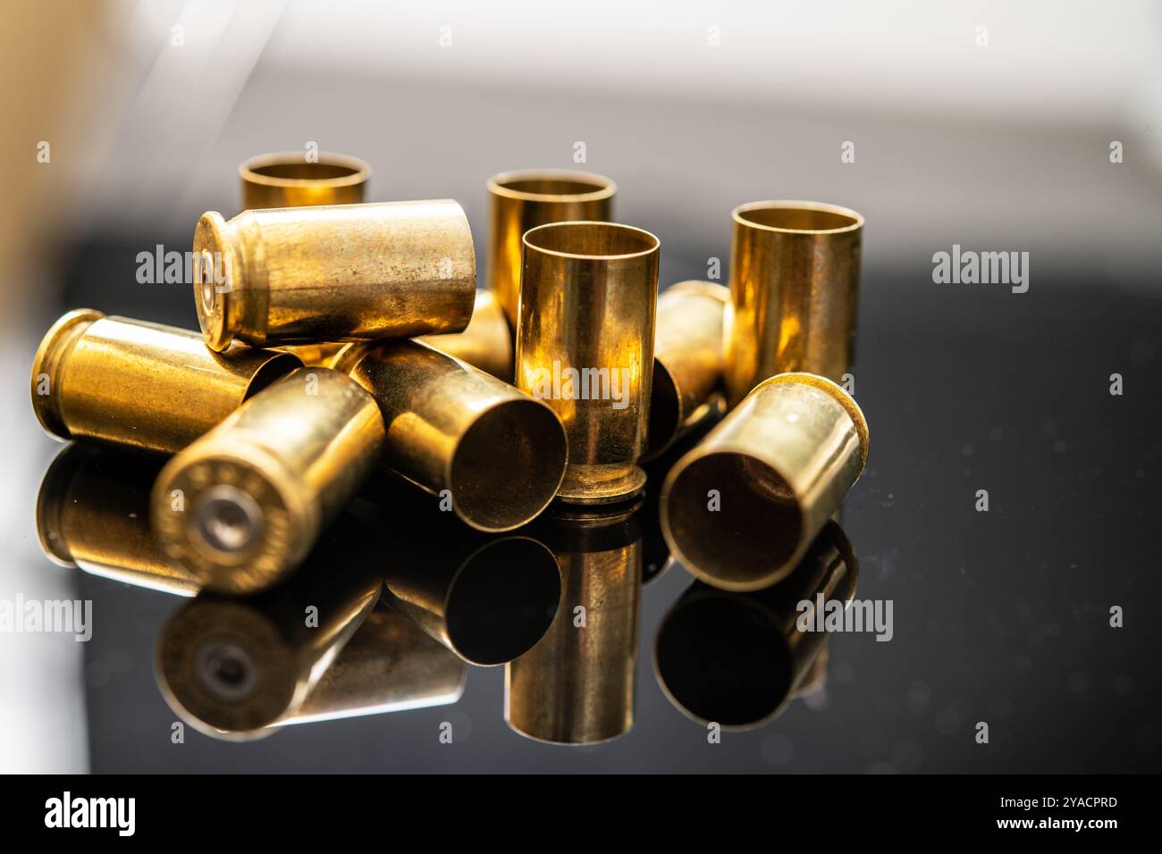 Una composizione dettagliata di involucri di proiettili in ottone che riflettono la luce, illustrano l'uso delle armi da fuoco, gli sport di tiro e la complessità delle munizioni. Perfe Foto Stock