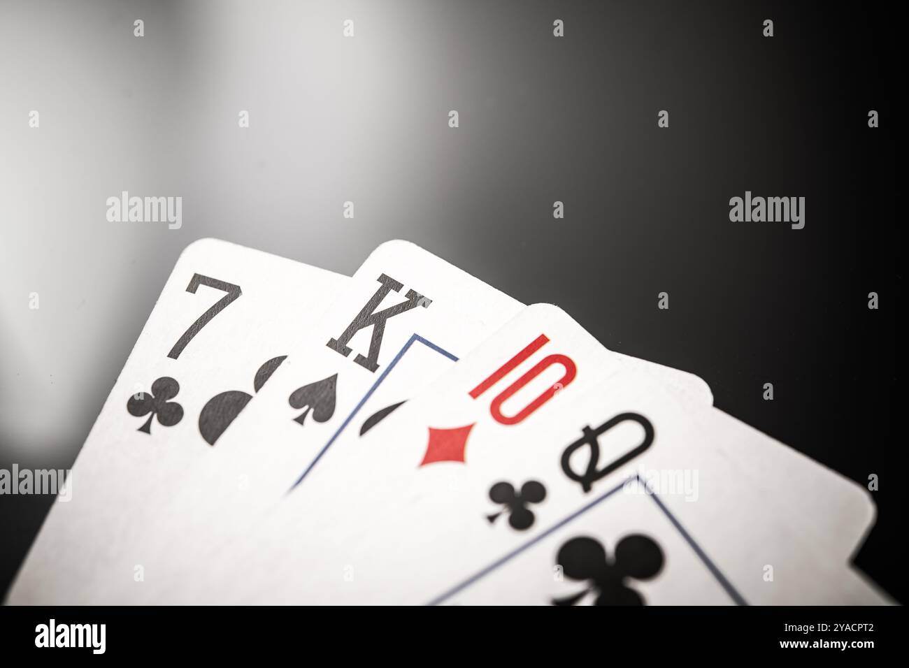 Primo piano di una mano di poker con una posta alta che comprende sette club, il re delle picche, dieci diamanti e la regina dei club. Perfetto per il gioco d'azzardo, la strategia, Foto Stock