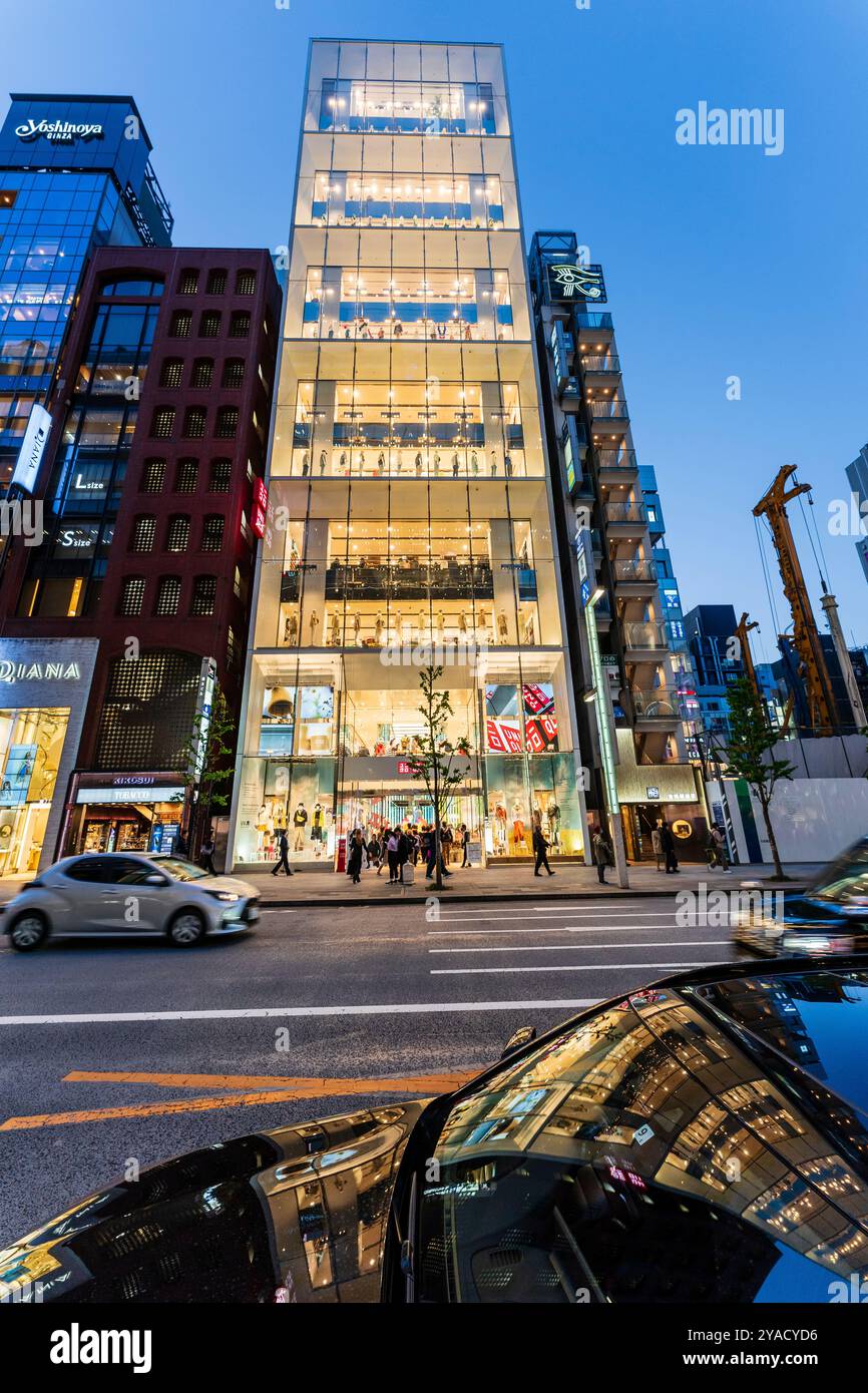 La sera dall'altra parte della strada vedrà l'entrata dell'elegante flagship store uni Qlo sulla Ginza. Manichini rivestiti nelle finestre del display. Foto Stock