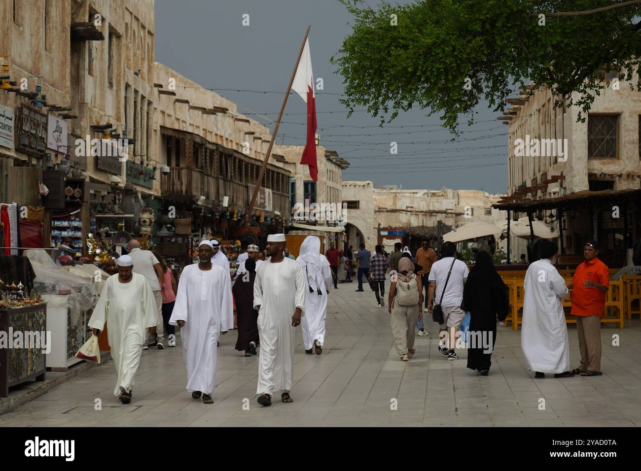 Souq Waqif, un vivace mercato nel cuore di Doha, Qatar, offre un ricco arazzo di cultura e tradizione. I visitatori possono esplorare una varietà di negozi che vendono spezie, tessuti e oggetti di artigianato, il tutto mentre si godono l'atmosfera vivace e la cucina locale. Questo souq storico rimane una destinazione chiave sia per i turisti che per la gente del posto, mostrando lo spirito del patrimonio del Qatar. Foto Stock