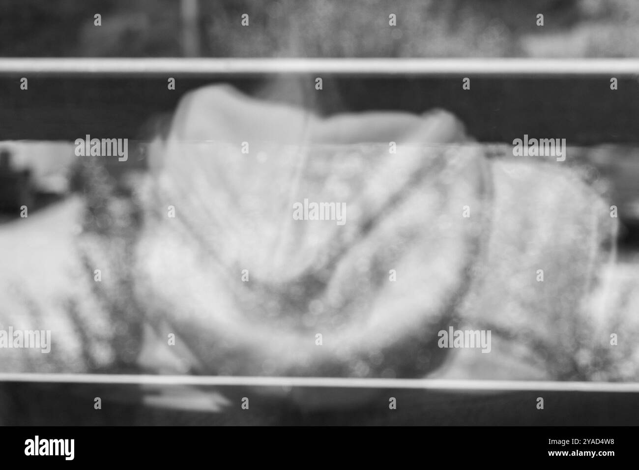 Riflesso con cappuccio bianco attraverso il vetro: Una prospettiva creativa Foto Stock