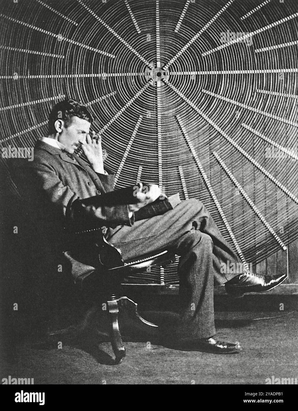 Nikola Tesla, con il libro di Rudjer Boscovich 'Theoria Philosophiae Naturalis', la bobina a spirale del suo trasformatore di bobina Tesla ad alta tensione - 1896 Foto Stock
