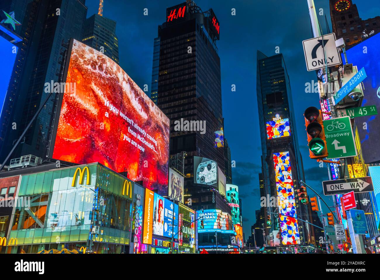 Times Square con cartelloni McDonald's e HM che illuminano il cielo notturno, la vivace scena cittadina di New York. STATI UNITI. Foto Stock
