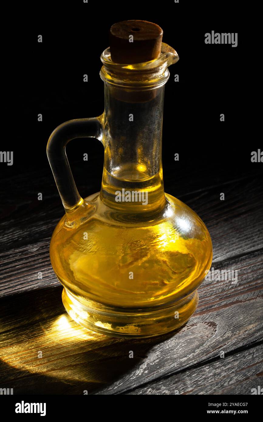 vaso di olio su fondo in legno nero Foto Stock