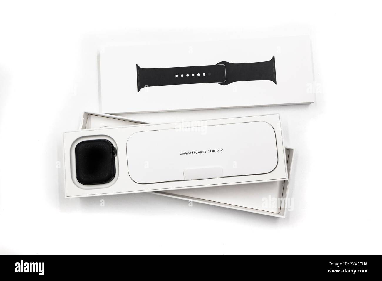 Confezione con la nuova configurazione dello smartwatch Apple Watch serie 10 del 2024, unboxing e braccialetto intercambiabile su sfondo blu Design elegante Foto Stock