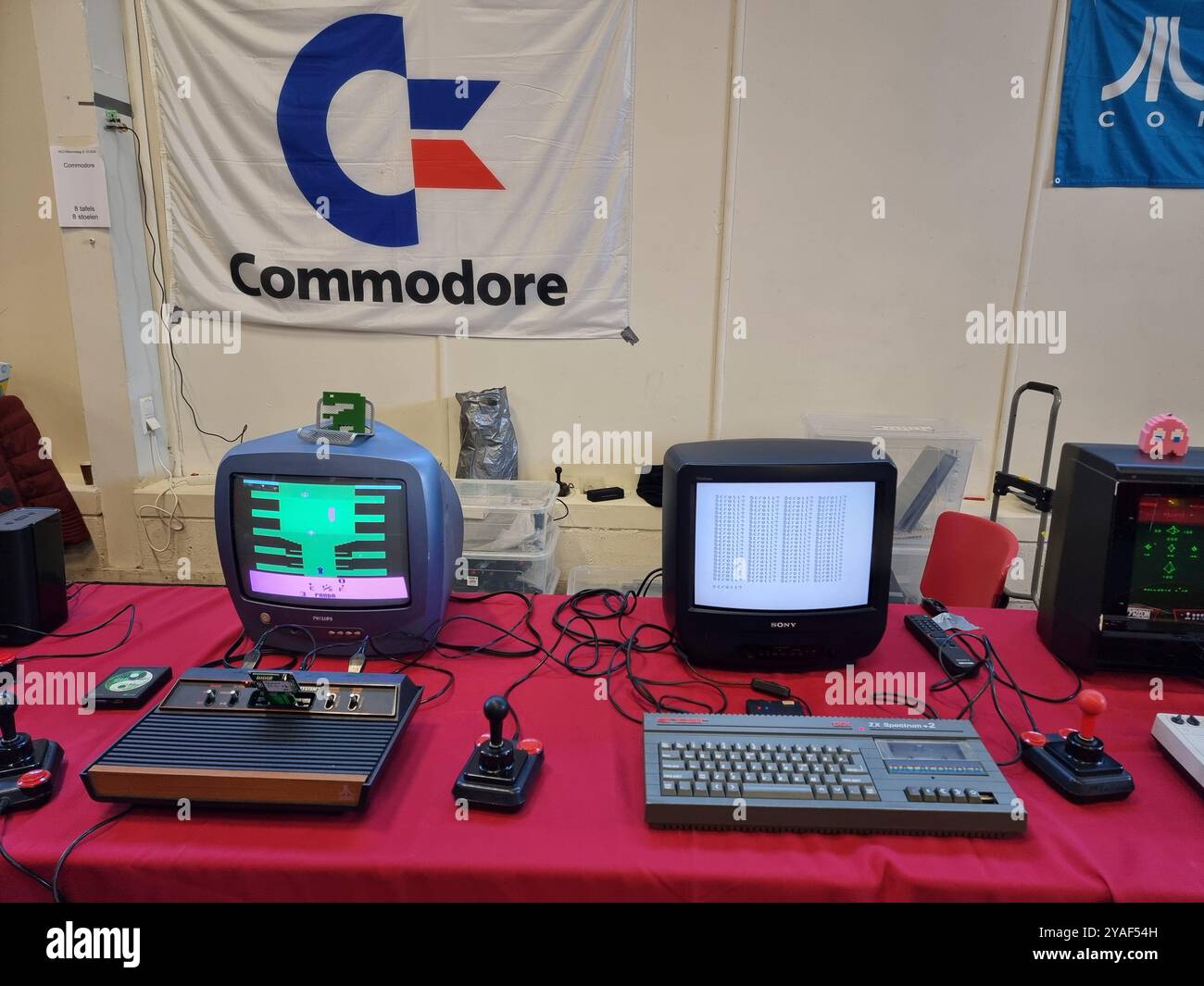 Vecchi, storici, computer Commodore d'epoca con monitor esposti su un tavolo rosso presso l'HCC Kennisdag di Expo Houten, Paesi Bassi Foto Stock