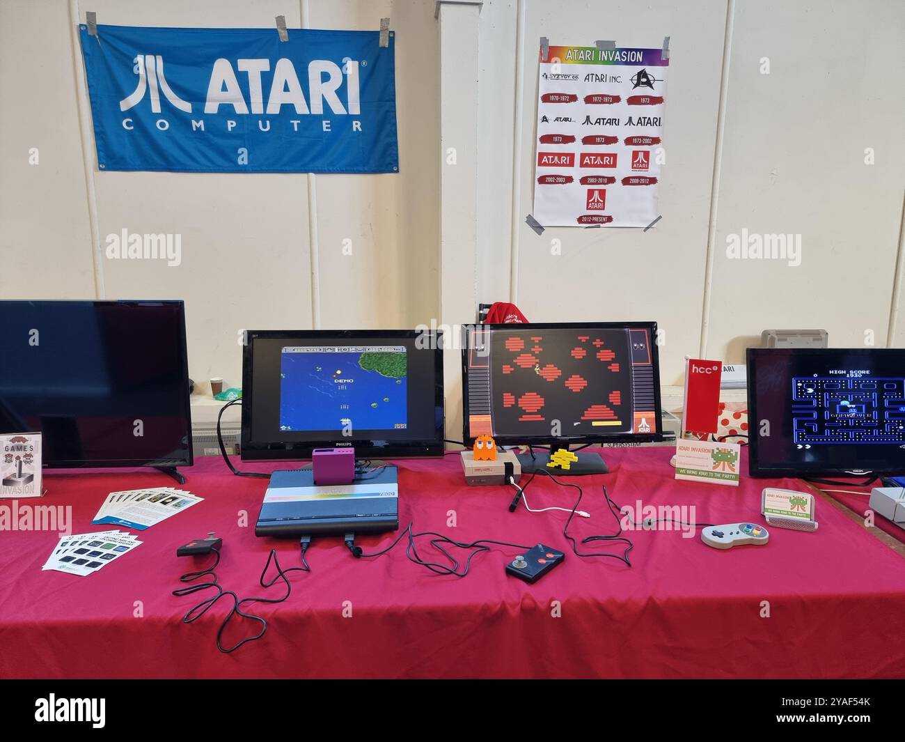 Vecchi, storici, computer Atari d'epoca con monitor esposti su un tavolo rosso presso l'HCC Kennisdag di Expo Houten, Paesi Bassi Foto Stock