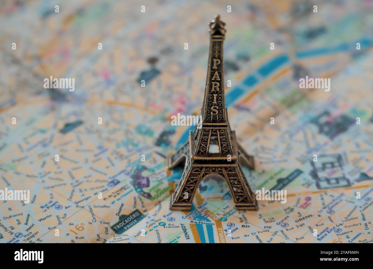 Una replica in miniatura in metallo della Torre Eiffel incombe sulla cartina stradale di Parigi per l'illustrazione e l'uso concettuale Foto Stock