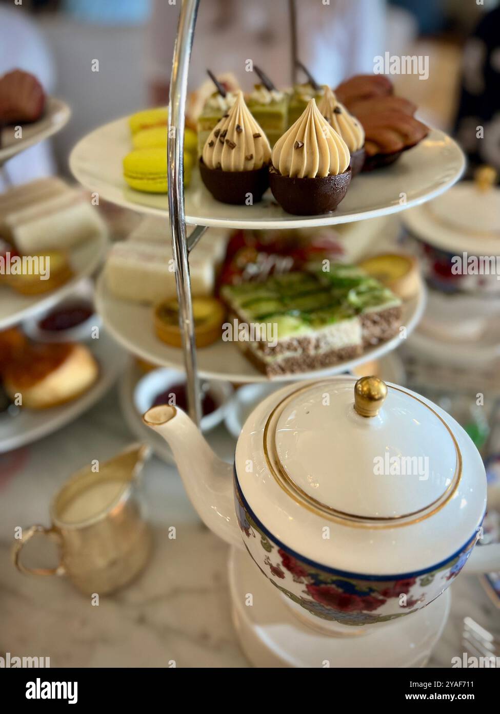 Un delizioso vassoio a più livelli di pasticcini, panini e dessert servito durante l'High Tea all'Empress Hotel, accompagnato dall'elegante cina Foto Stock