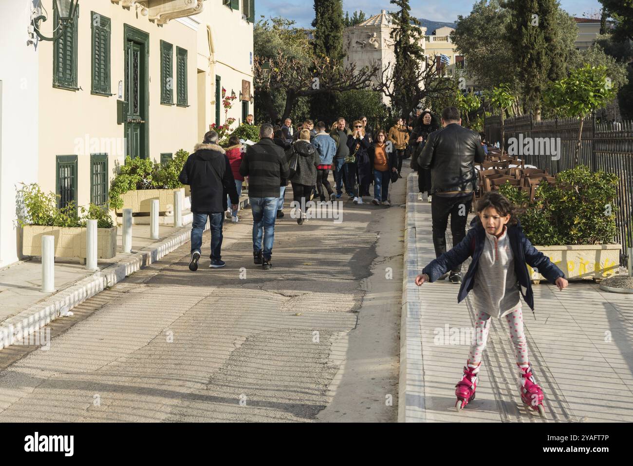 Città vecchia di Atene, Attica, Grecia, 12 28 2019 bambini con lame a rullo e persone che camminano per le strade della città vecchia intorno all'Acropoli, in Europa Foto Stock