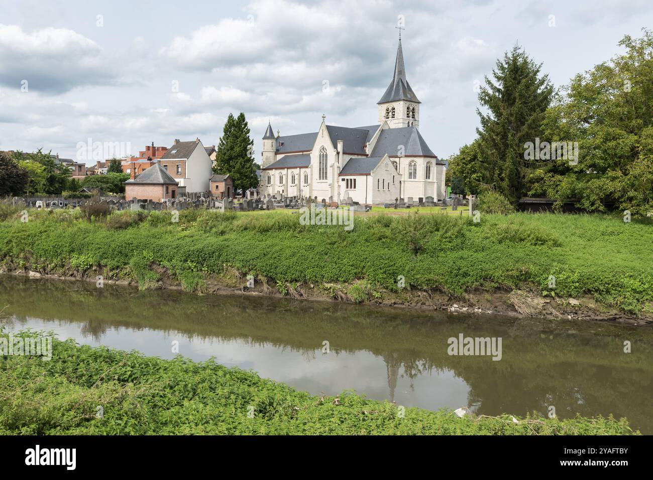 Vilvoorde, regione fiamminga del Brabante, Belgio, 08 24 2021 Vista idilliaca su una vecchia chiesa bianca sul fiume Senne con dintorni verdi, Europa Foto Stock