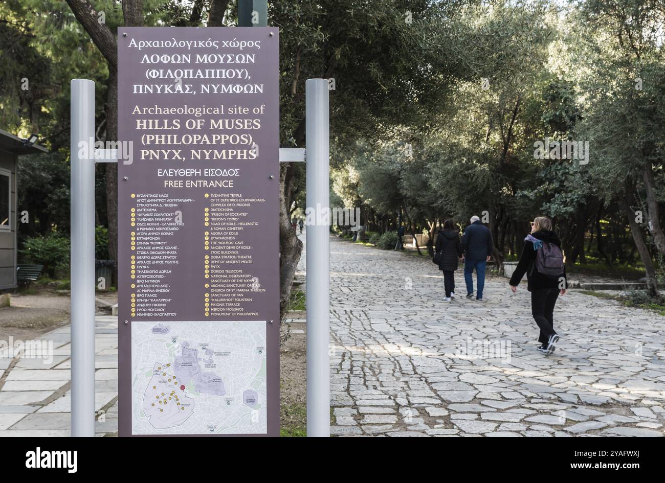 Città vecchia di Atene, Attica, Grecia, 12 28 2019 visitatori che passano un cartello informativo presso il sito archeologico delle colline di Muses, Europa Foto Stock