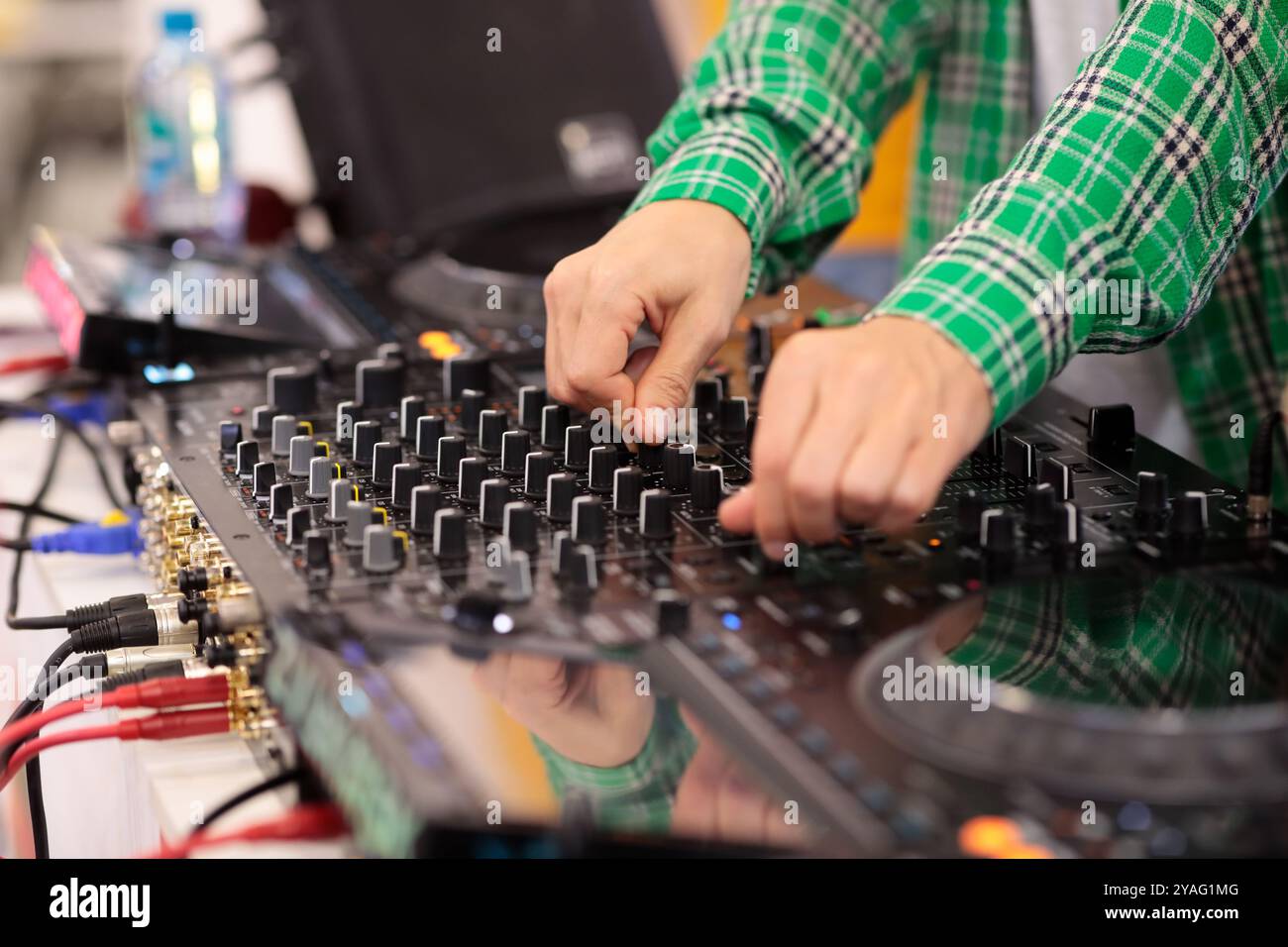 Primo piano di un DJ che mixa musica su una console di mixaggio. Messa a fuoco selettiva. Foto Stock