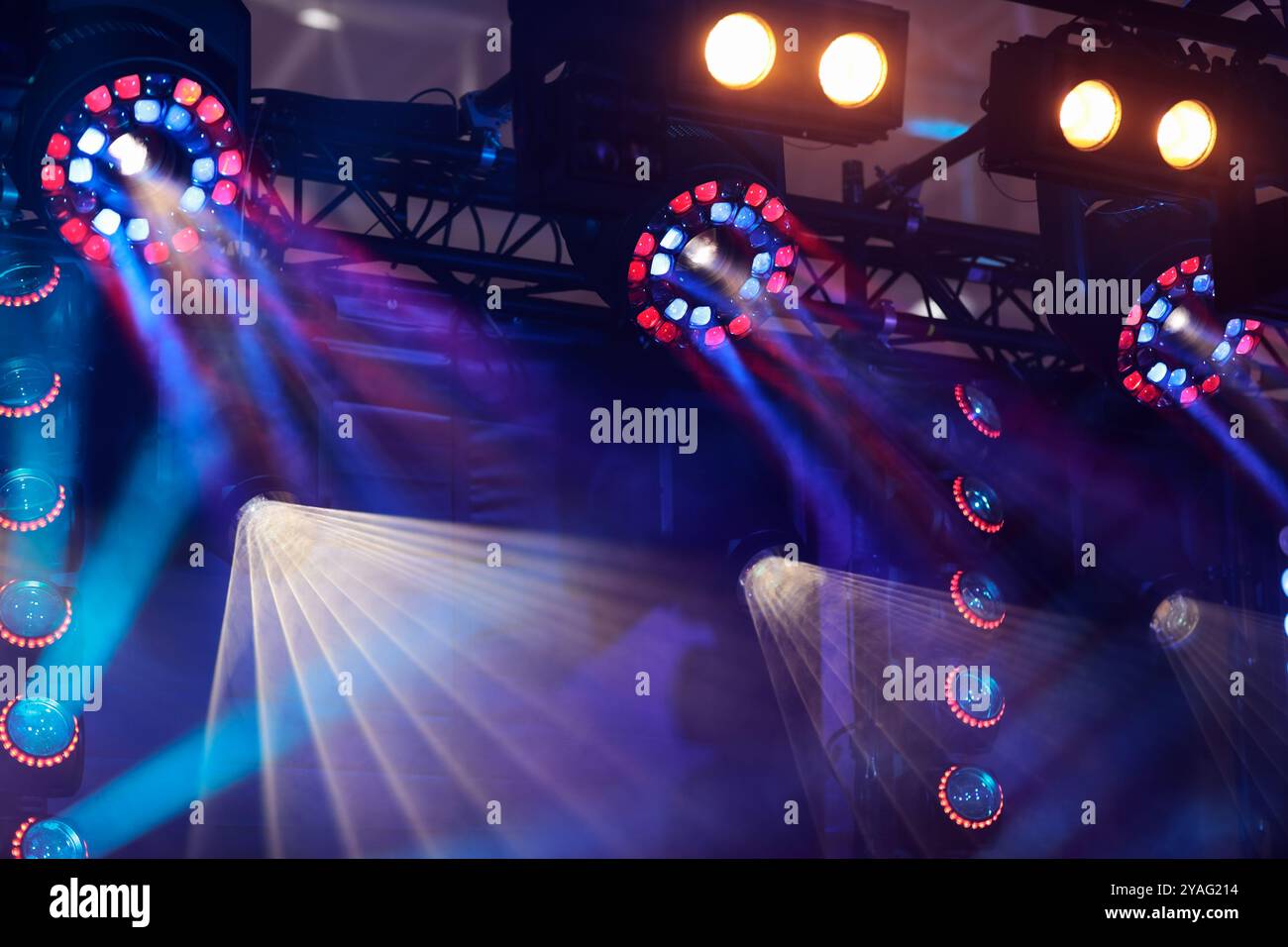 Scena di concerti con illuminazione colorata del palcoscenico. Vari impianti di illuminazione a LED sospesi su una capriata. Messa a fuoco selettiva. Foto Stock