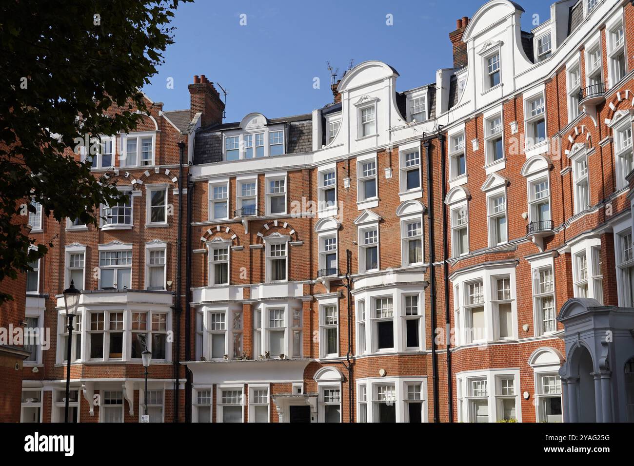 Eleganti e colorate vecchie case cittadine in mattoni e appartamenti nel quartiere Chelsea di Londra Foto Stock