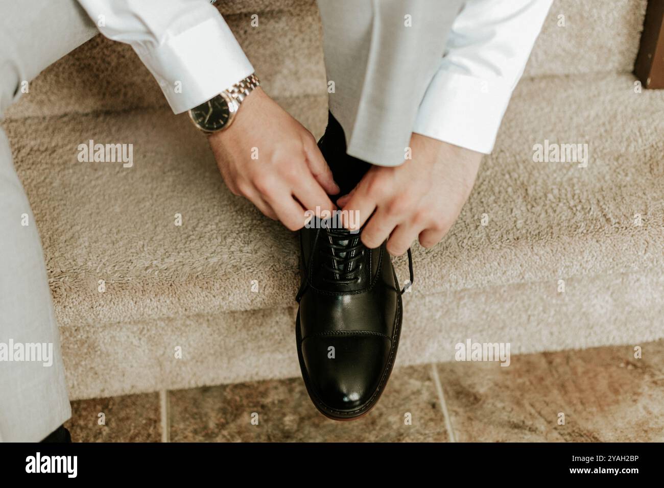 lo sposo si prepara a legare una scarpa nera Foto Stock