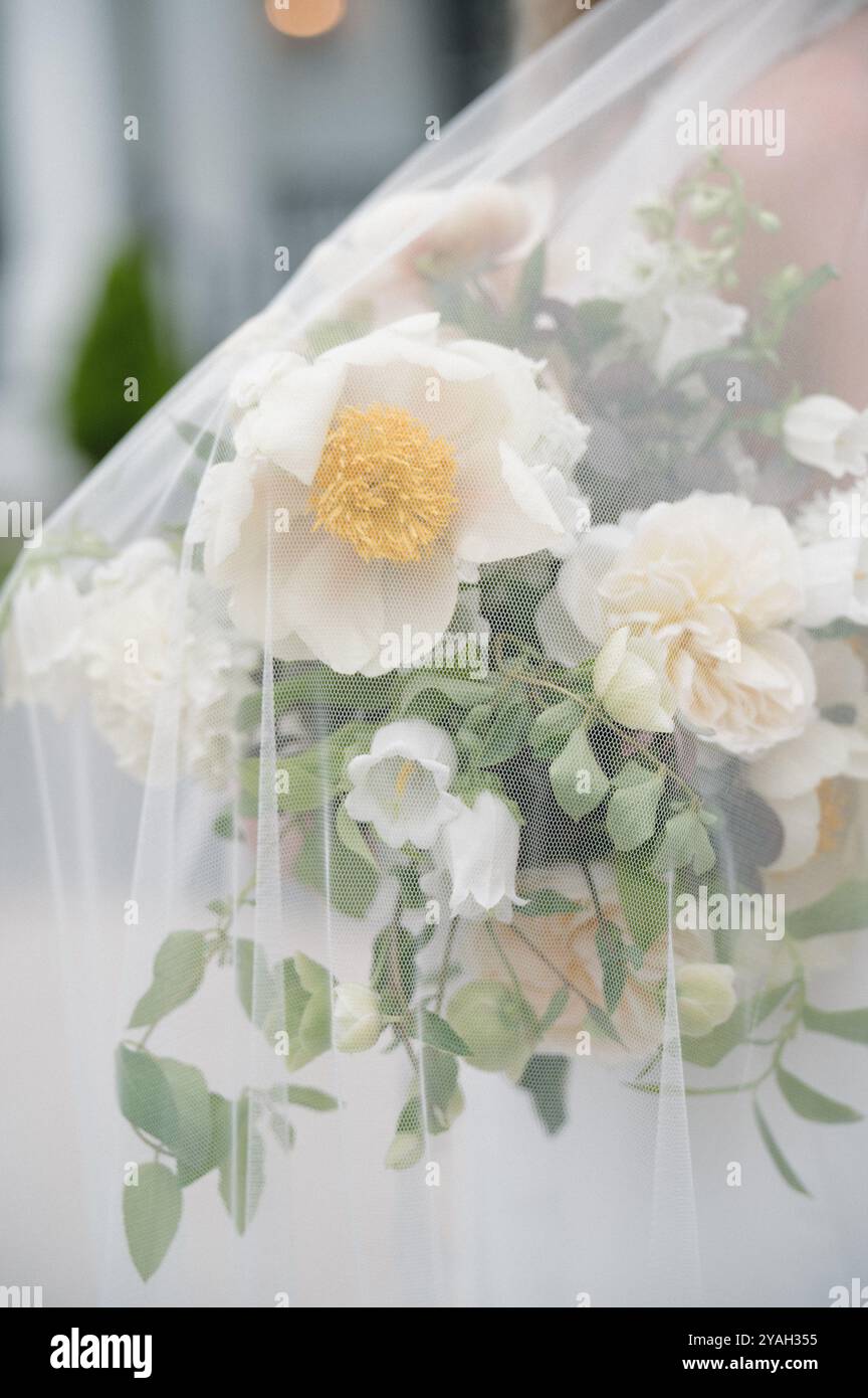 Sposa con bouquet nuziale bianco e verde sotto il velo Foto Stock