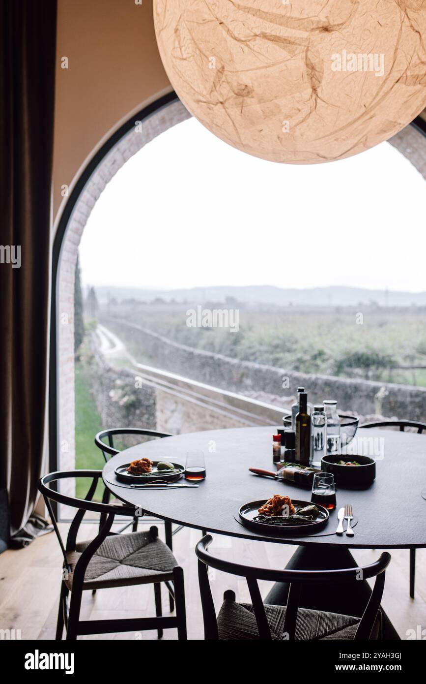 Moderno tavolo da pranzo con vista sul vigneto e disposizione minima del tavolo Foto Stock