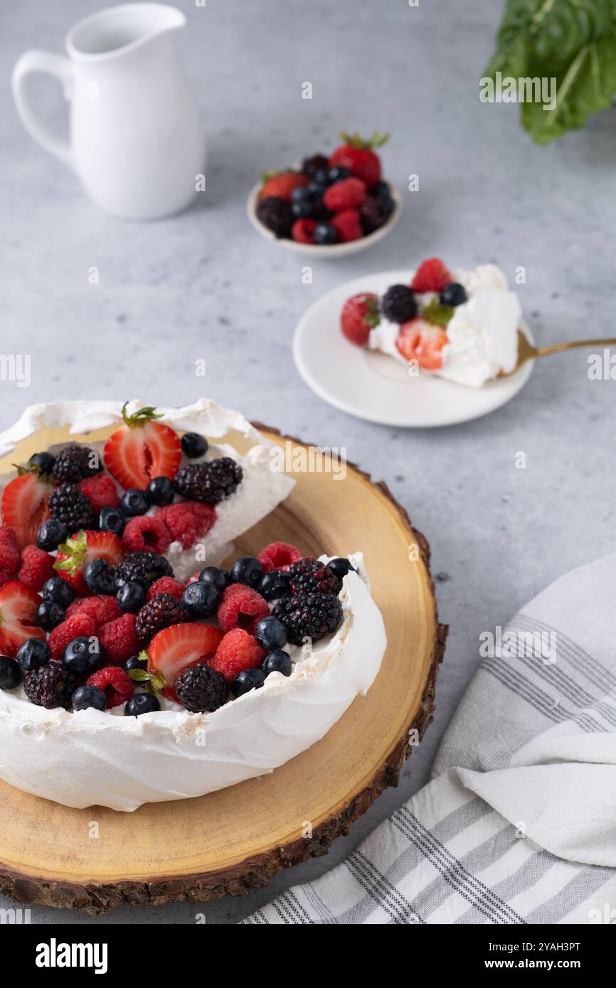 Pavlova condita con una varietà di frutti di bosco Foto Stock