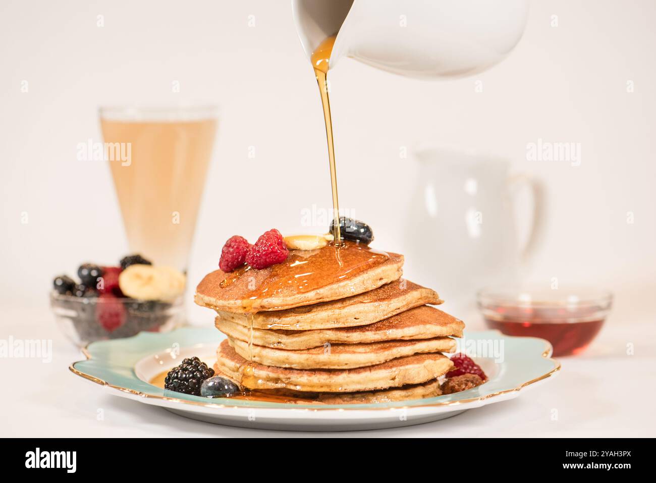 Sciroppo d'acero versato su una pila di pancake Foto Stock