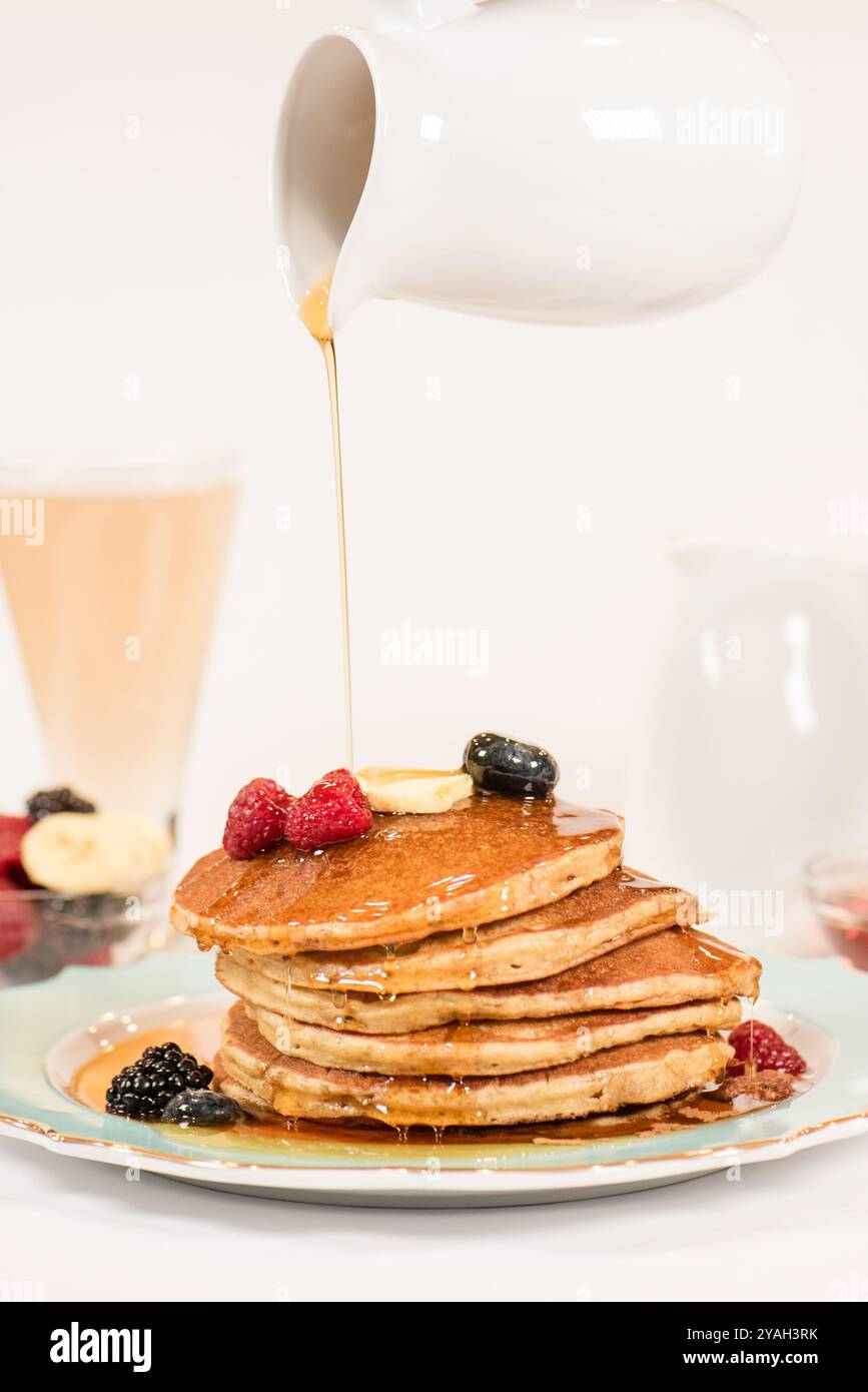 Sciroppo versato su una pila di pancake Foto Stock