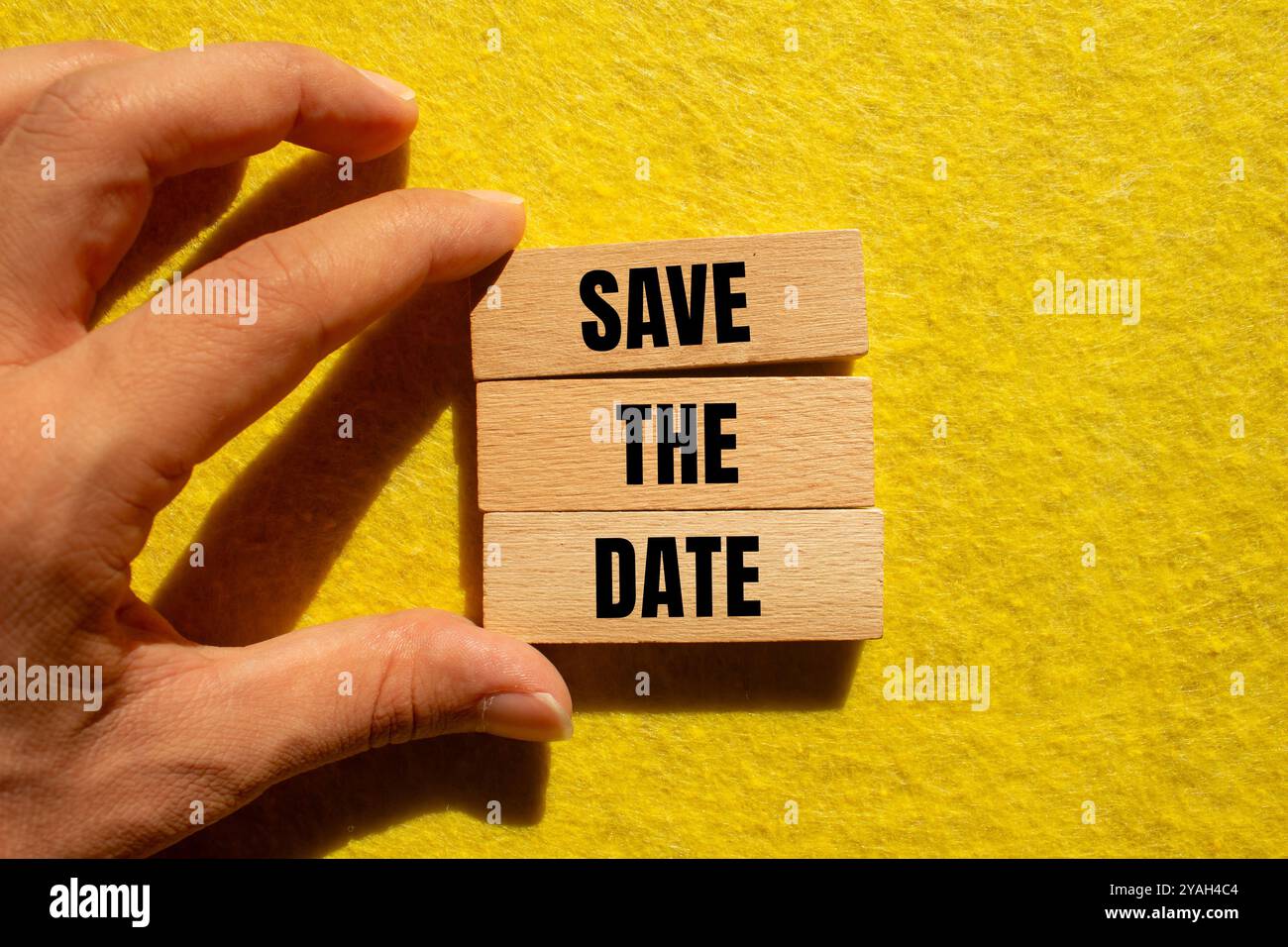 Salvare il messaggio della data scritto su blocchi di legno con sfondo giallo. Salvare il simbolo della data concettuale. Foto Stock