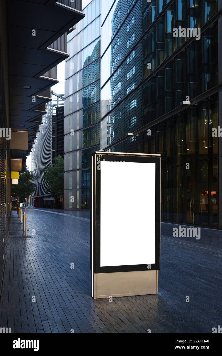 Cartellone digitale vuoto in un passaggio pedonale tra moderni edifici per uffici nel quartiere degli affari di Londra Foto Stock