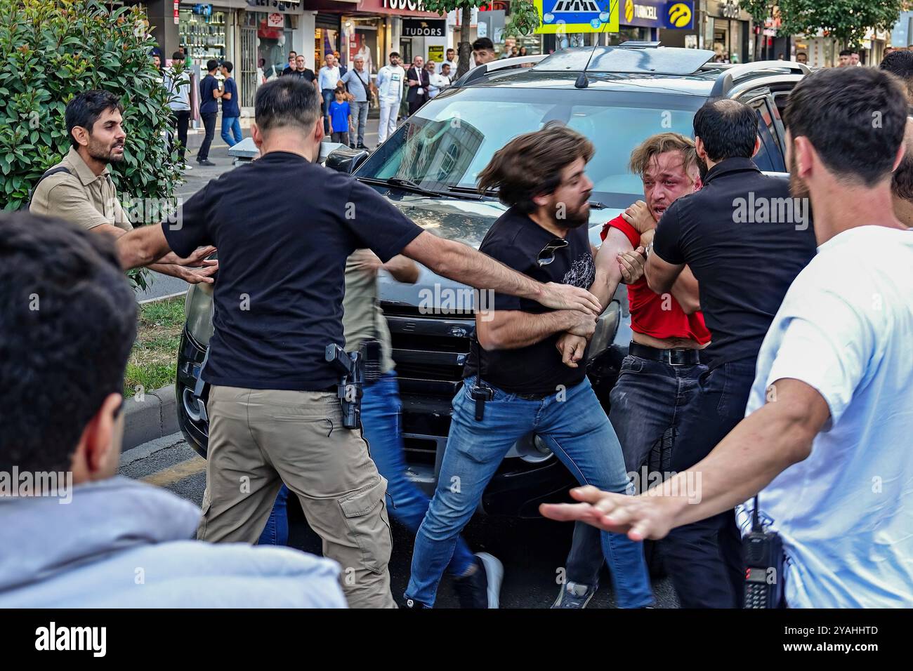 Un giovane curdo (in tessuto rosso) viene portato in un'auto della polizia dopo essere stato arrestato dalla polizia turca dopo una dichiarazione stampa. Ai partiti politici e alle organizzazioni curde non è stato permesso di organizzare un "grande raduno della libertà" nella città di Diyarbakir per il rilascio di Abdullah Ocalan, il leader dell'organizzazione armata curda, il Partito dei lavoratori del Kurdistan (PKK), che è stato imprigionato per 25 anni, e per la soluzione democratica della questione curda. A Diyarbakir, una folla di politici curdi e centinaia di persone si sono riunite di fronte all'AZC Plaza nel centro della città e hanno voluto marciare verso il centro Foto Stock
