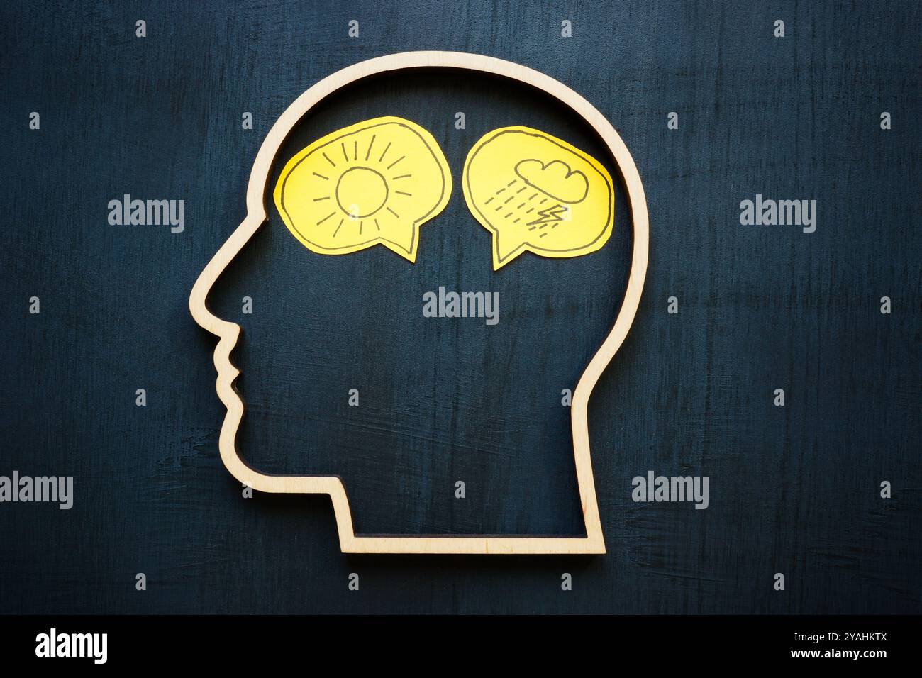 Un contorno di una testa con simboli di emozioni negative e positive. Rappresenta l'equilibrio emotivo. Foto Stock